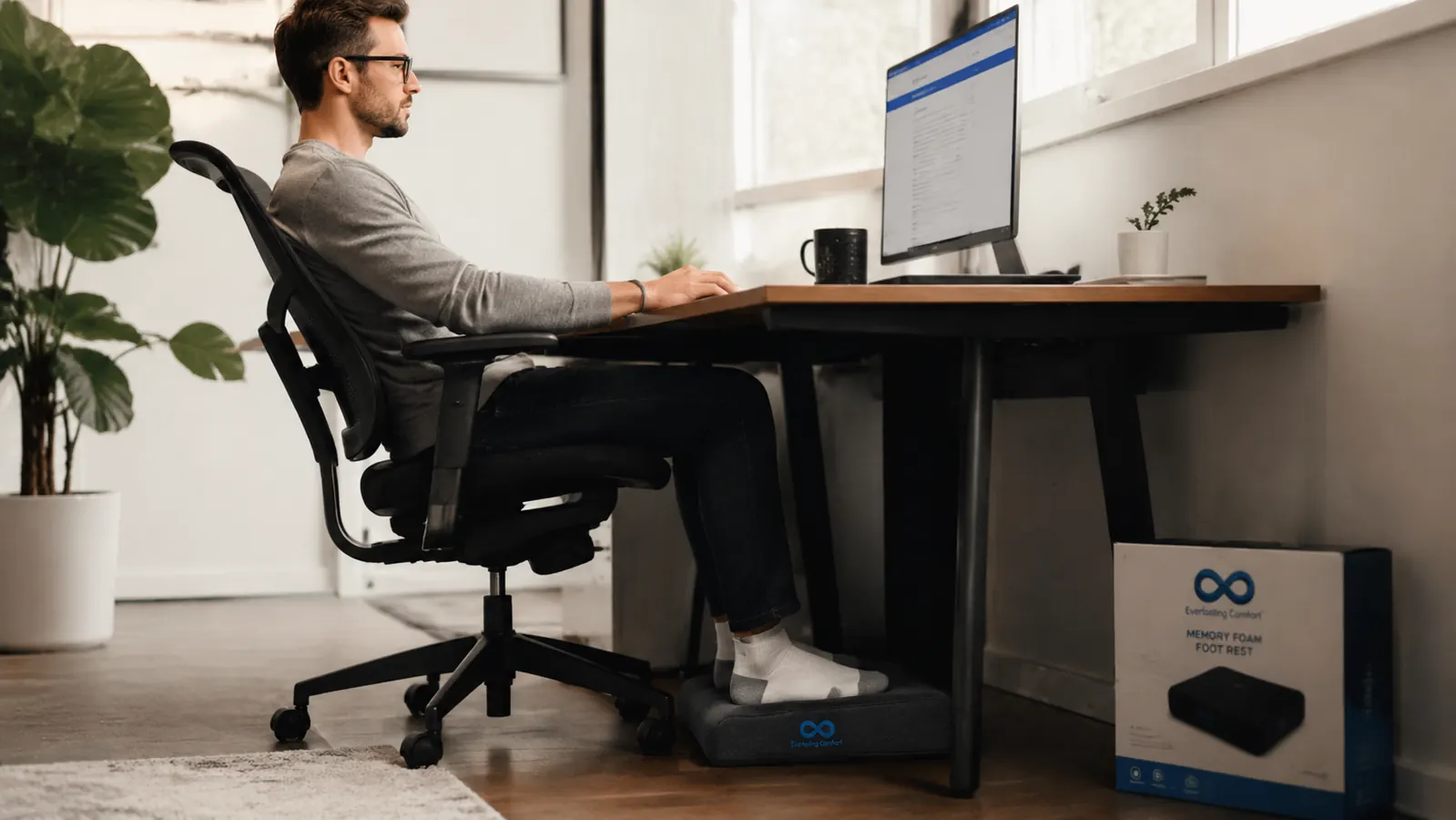 Person in an ergonomic office chair with feet placed flat on a memory foam footrest, side profile view