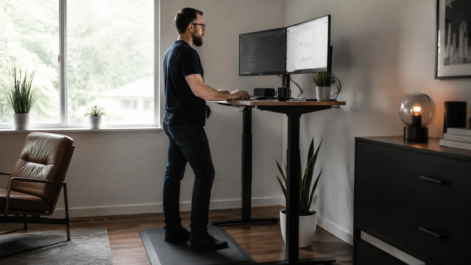 Person at a standing desk with a mat underneath, comfortable posture, looking at two monitors