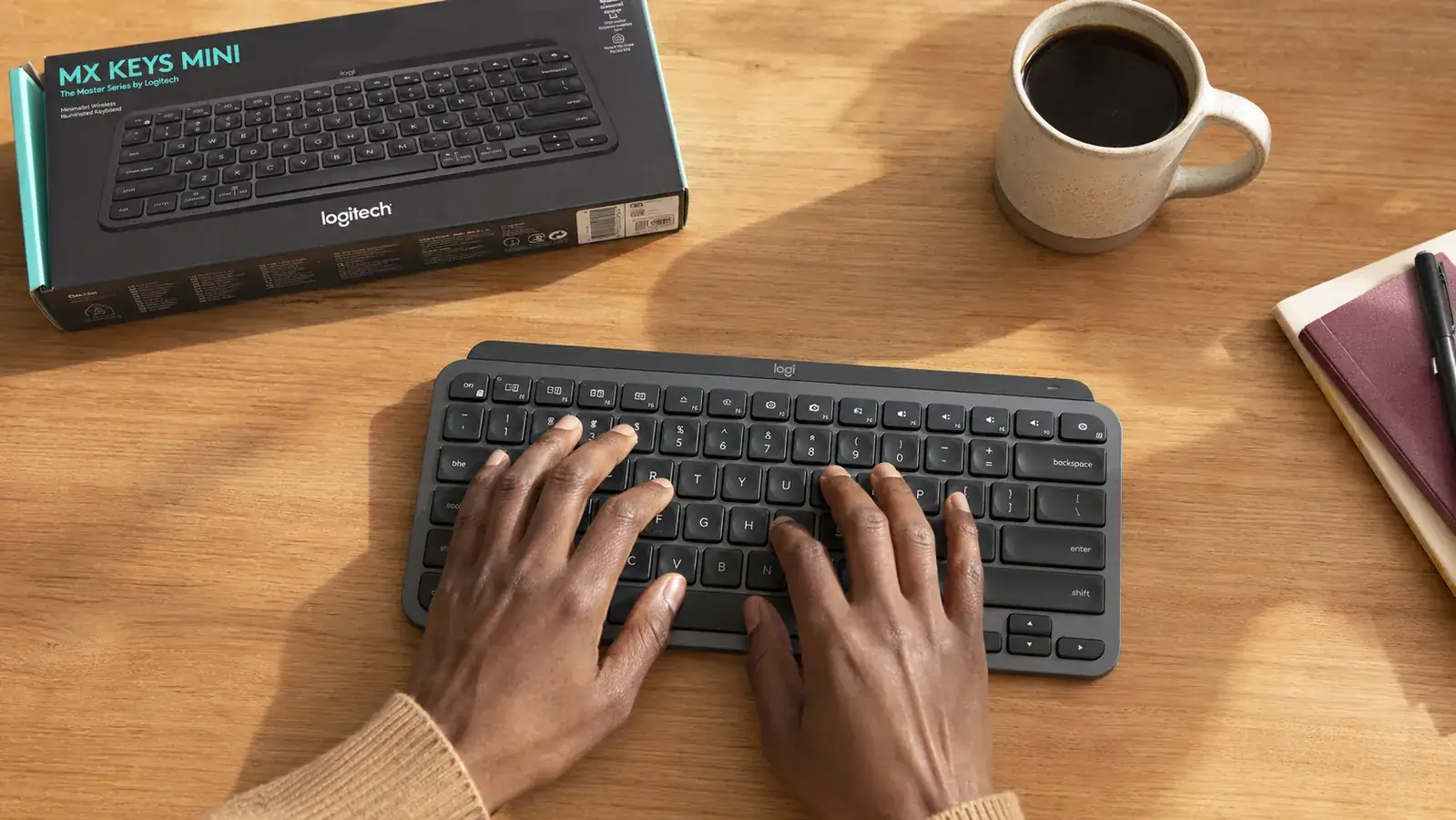 Close-up of hands typing on the Logitech MX Keys Mini compact keyboard