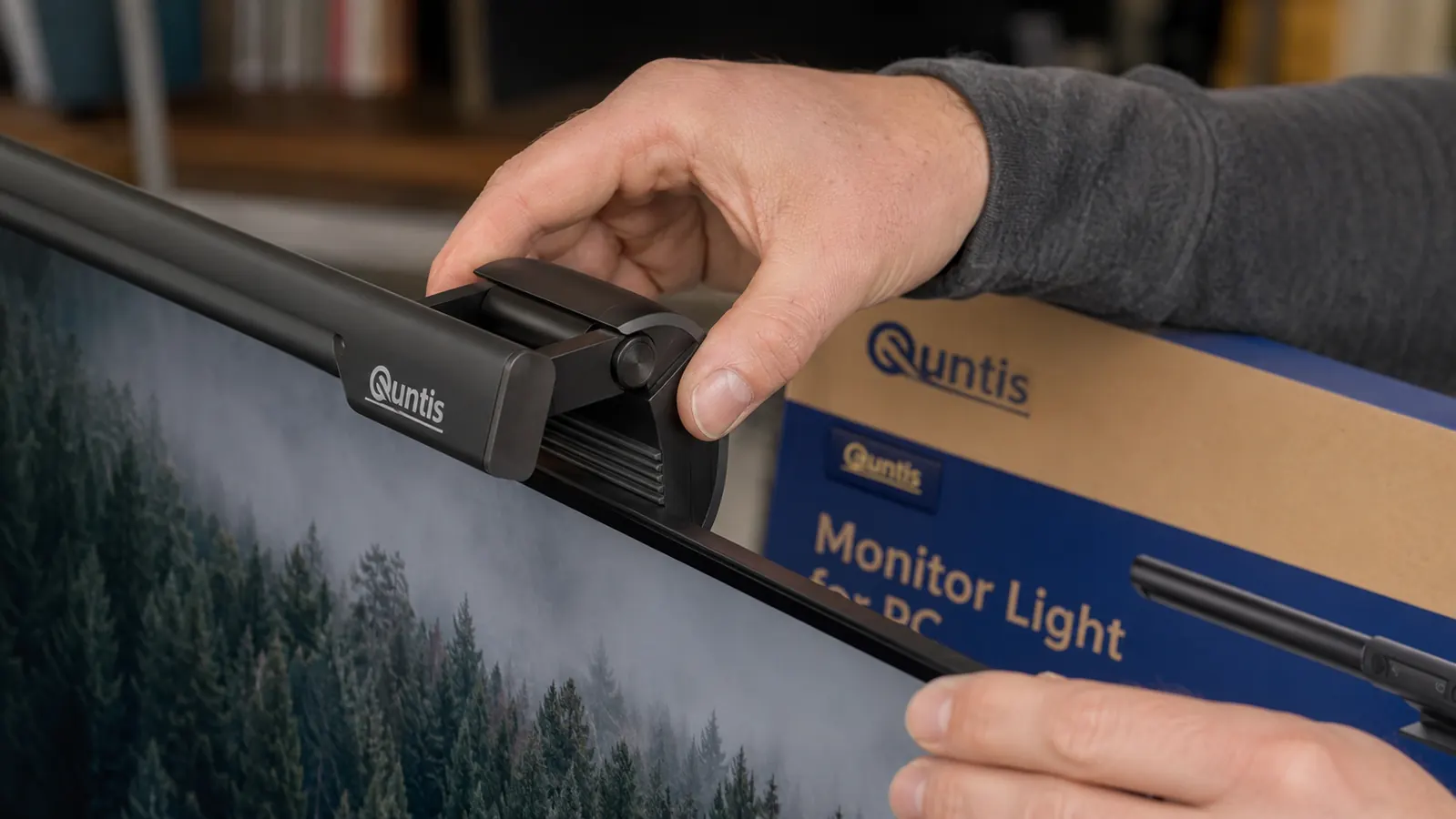Quntis monitor lamp clip attached to a slim monitor bezel showing the rubber pad contact point