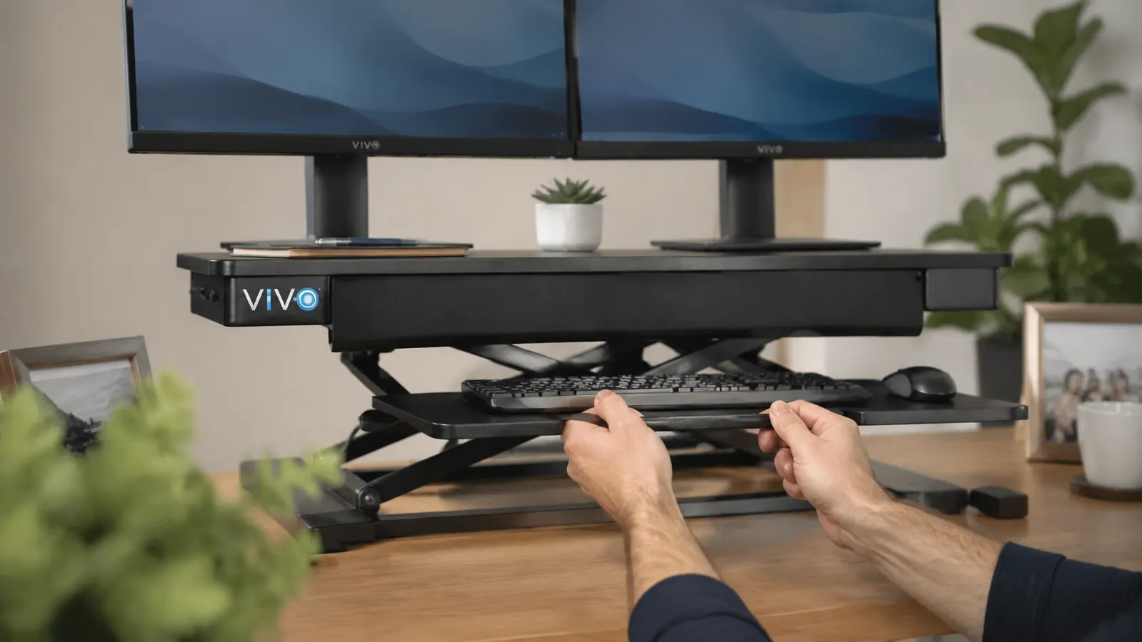 Close-up of hands adjusting the VIVO desk converter gas-spring lift handle while the monitor platform rises